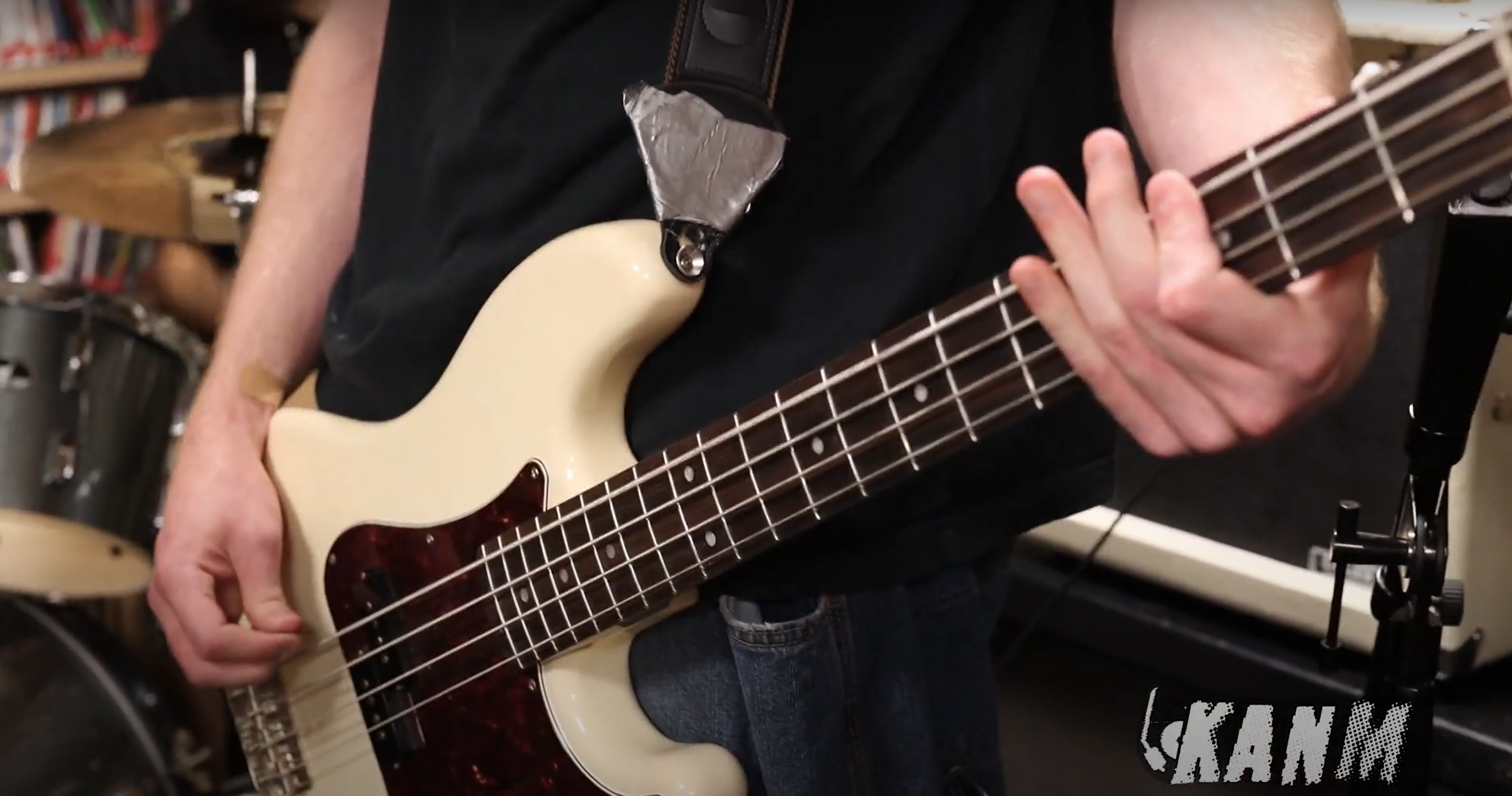 A close up of a bass guitar being played by a musician.